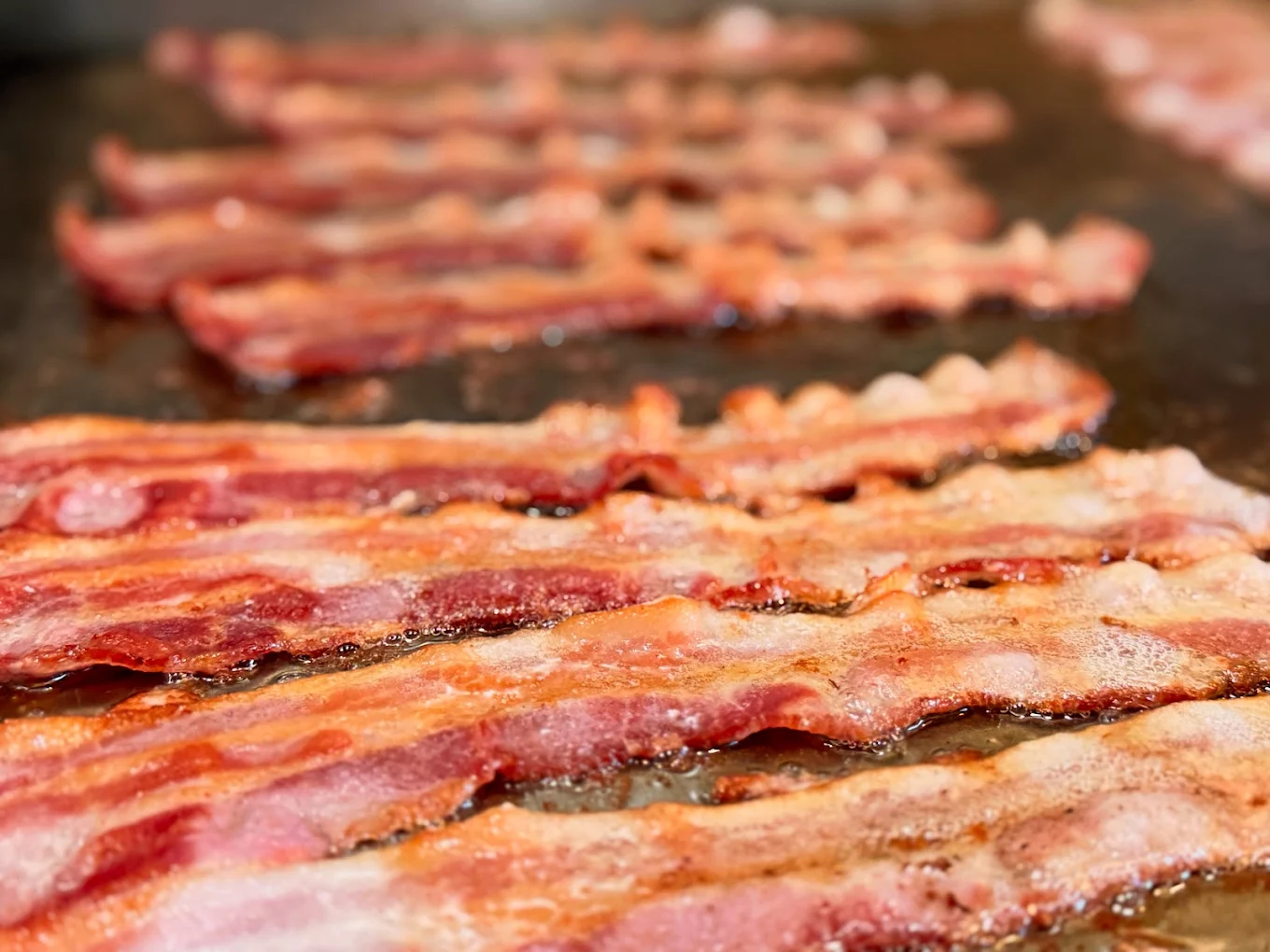 Sizzling bacon on the griddle